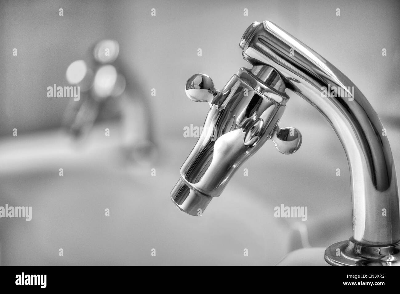 A photograph of a bathroom sink tap in black & white Stock Photo Alamy