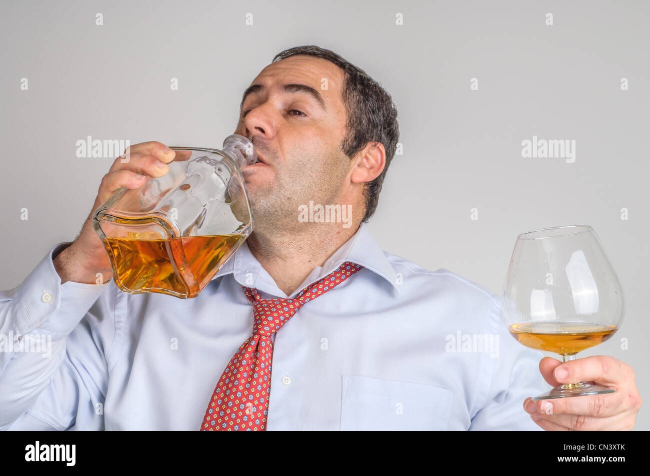 Drunk Businessman drinking whisky Stock Photo Alamy