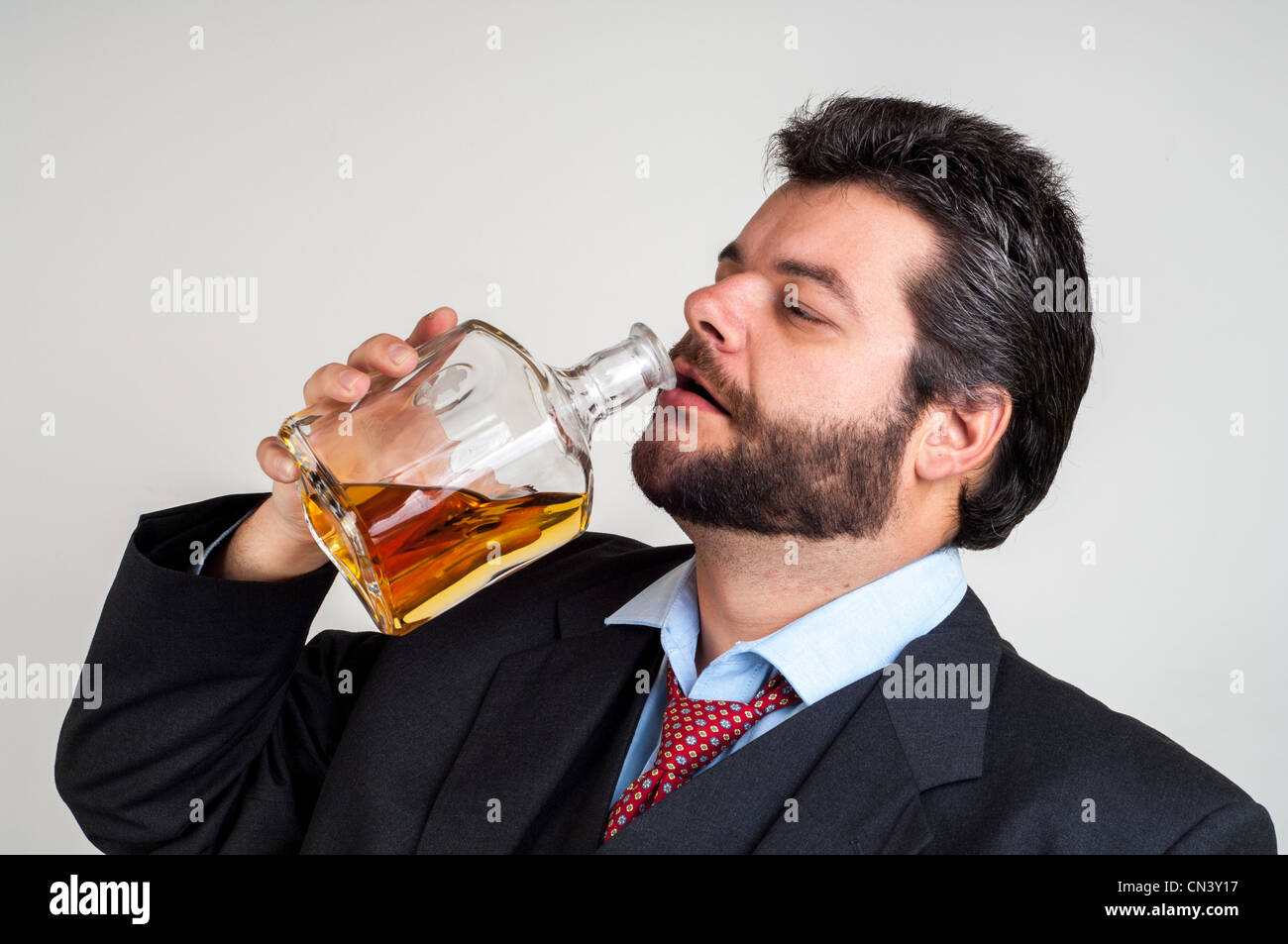 Drunk Businessman Drinking from a Bottle of whisky Stock Photo Alamy