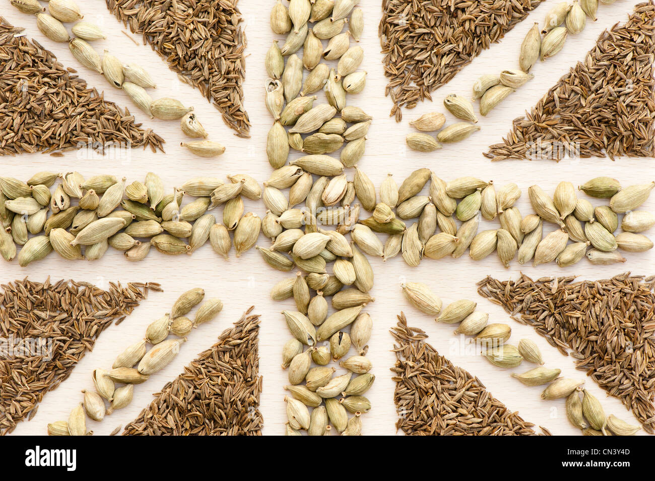 Union Flag created out of curry spices: whole cumin seeds and cardamom pods Stock Photo