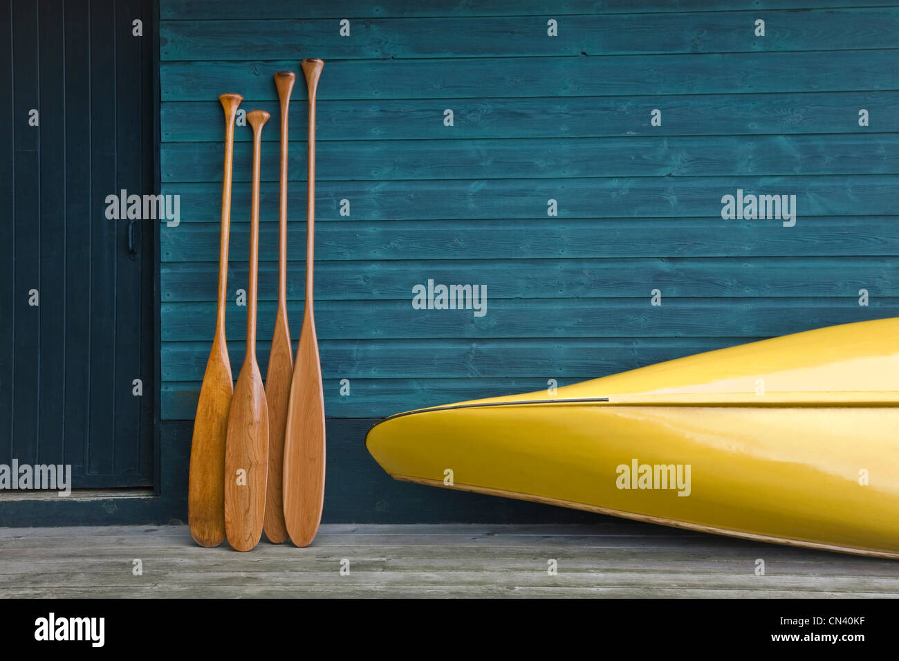 Yellow canoe and paddles on dock, Algonquin Park, Ontario Stock Photo