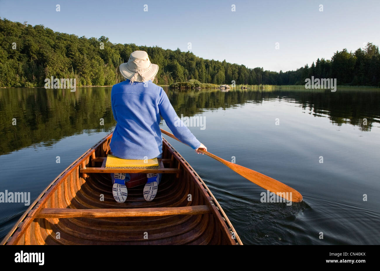 Woman paddling canoe on Smoke Lake, Algonquin Park, Ontario Stock Photo