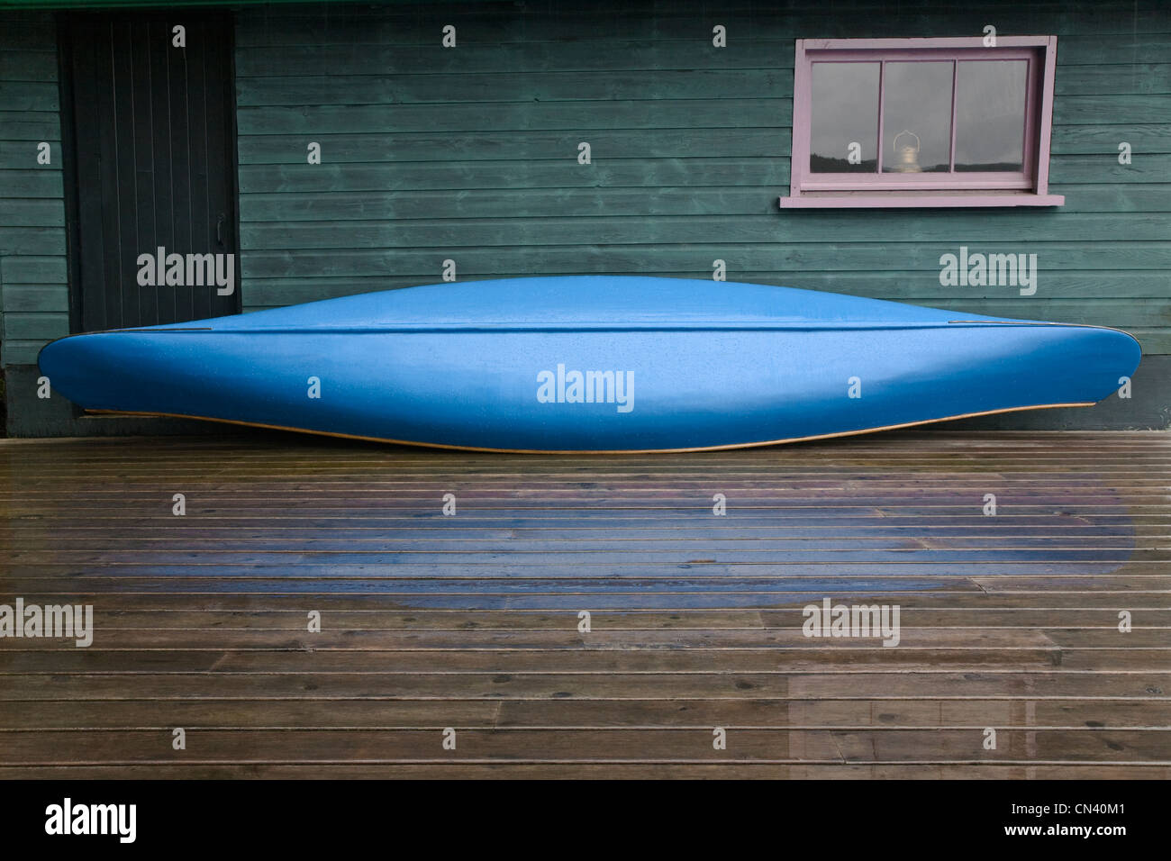 Blue canoe with raindrops on dock, Algonquin Park, Ontario Stock Photo