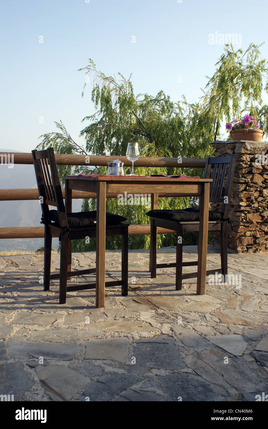 dinner for two, table with two chairs outside on a slate veranda/balcony Stock Photo