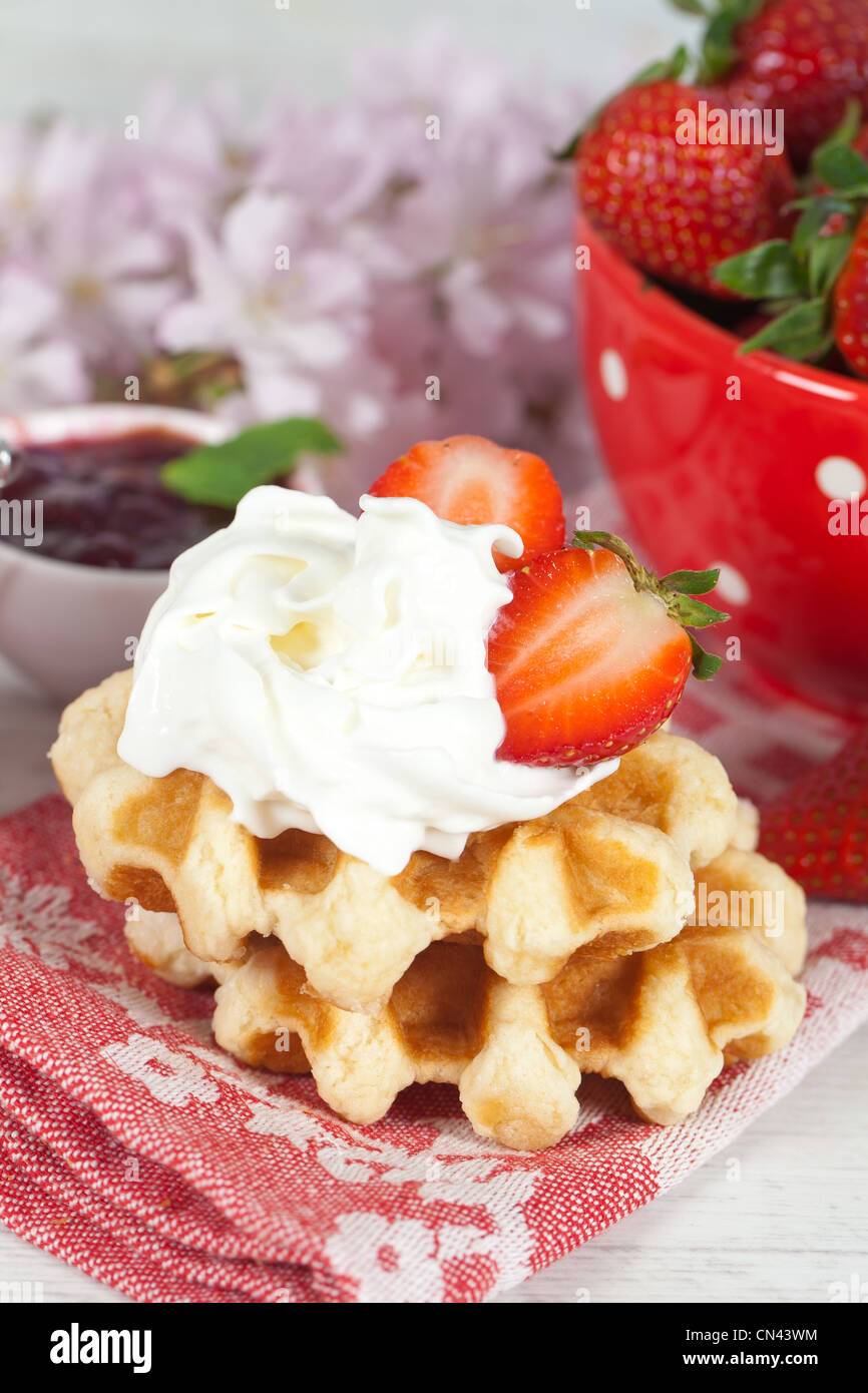 Delicious waffle with whipped cream and strawberries Stock Photo - Alamy