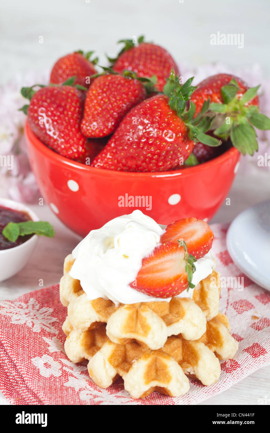 Delicious waffle with whipped cream and strawberries Stock Photo - Alamy