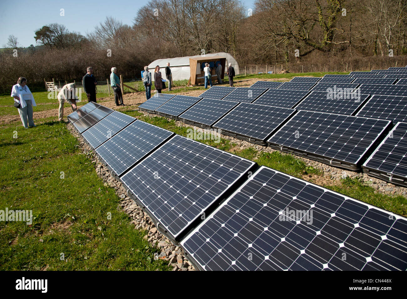 People looking at the Photovoltaic cells in an array in a field at the National Trust, Llanerchaeron, Ceredigion, Wales UK Stock Photo