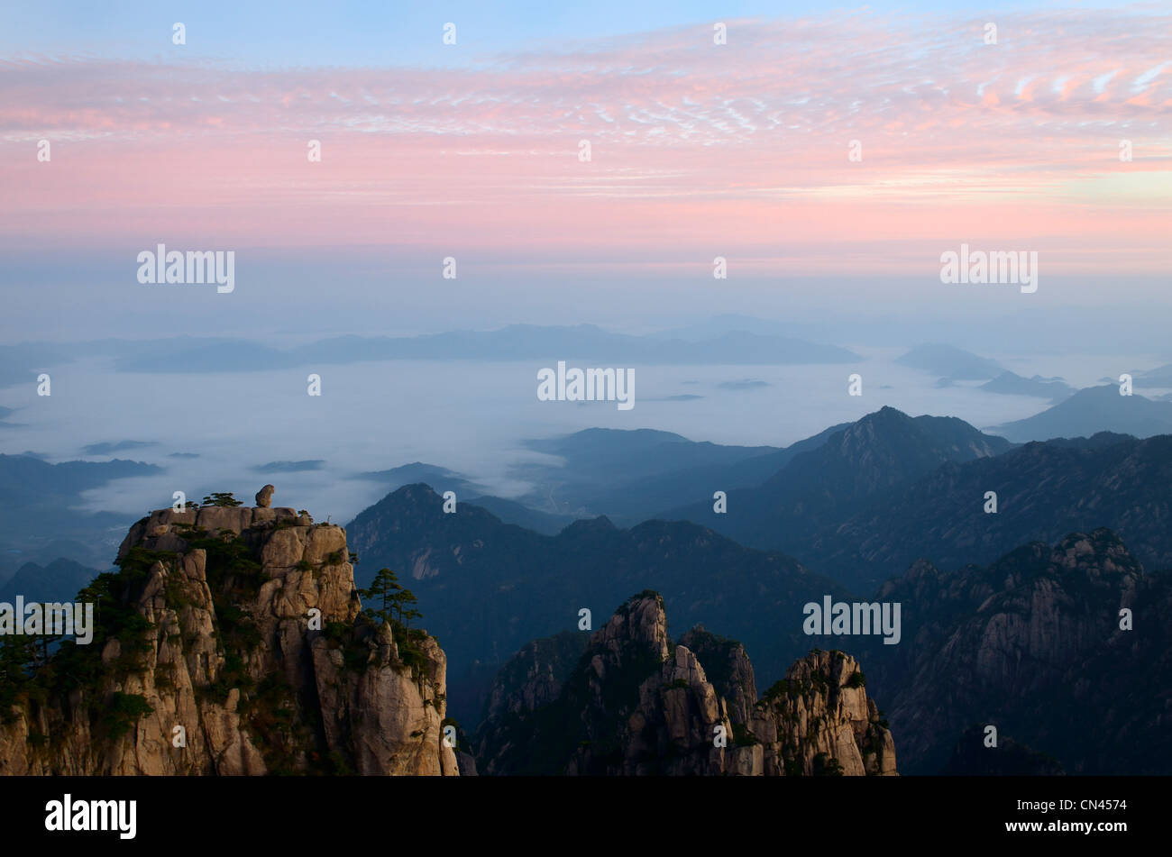 Sunrise pink sky at Monkey watching the Sea Peak with fog in valley at Huangshan Yellow Mountain Peoples Republic of China Stock Photo