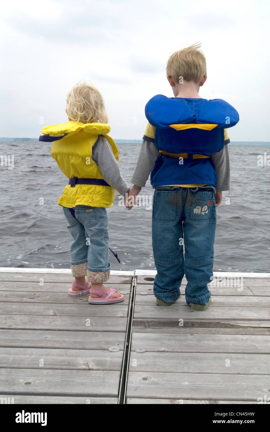 Brother and Sister Holding Hands on a Dock in Life Jackets, Lake ...