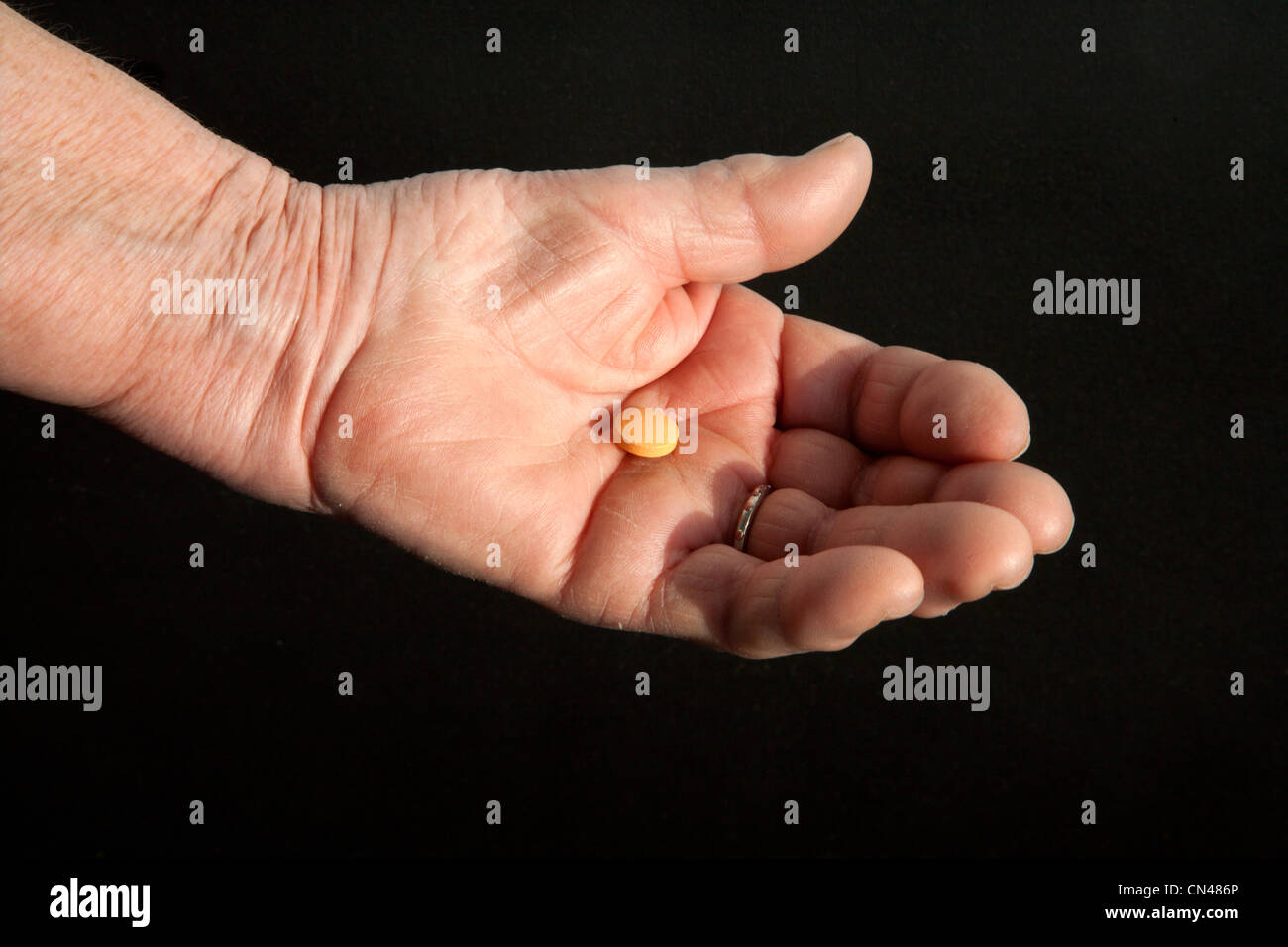 pill on the hand of old woman Stock Photo