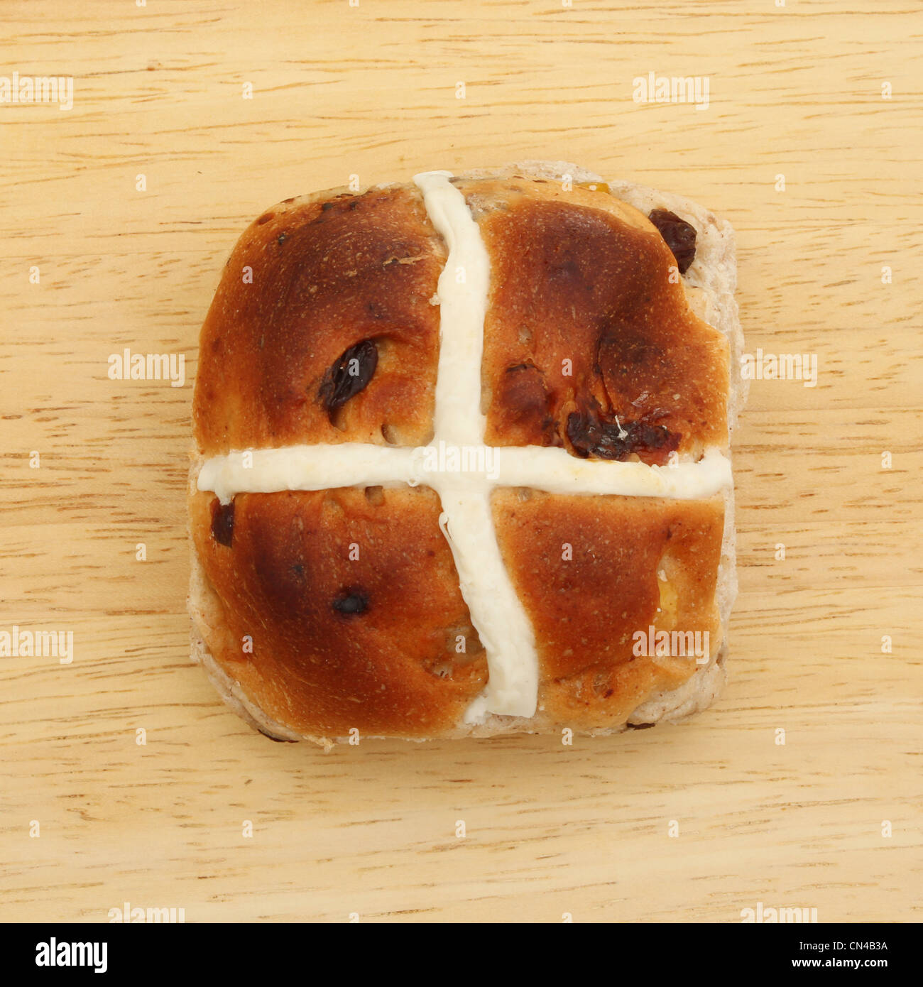 Single hot cross bun on a wooden board Stock Photo