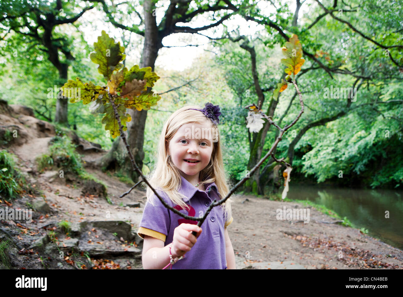 Girl holding an oak branch in a woodland Stock Photo