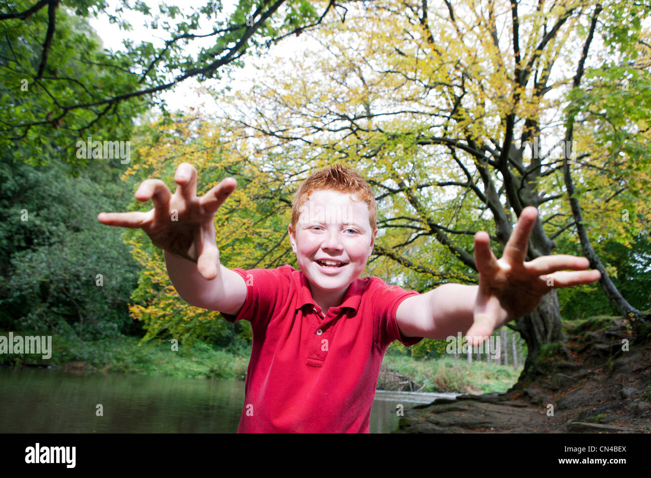 Boy pretending to be a monster in a woodland Stock Photo