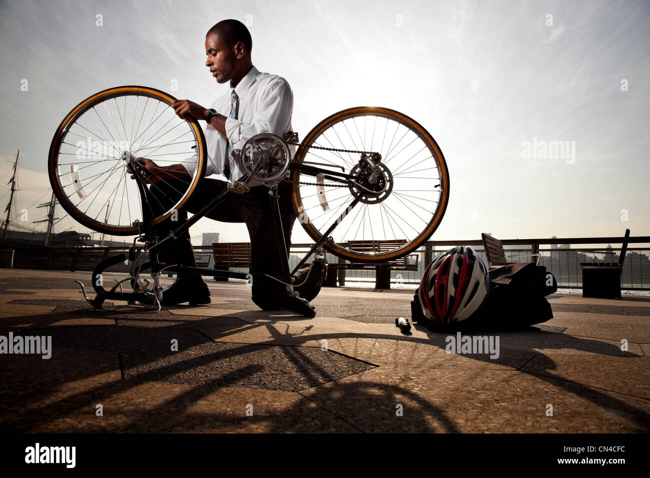 Young businessman reparing bicycle Stock Photo