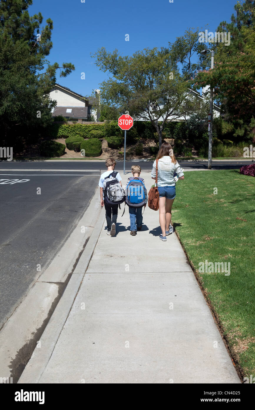 Boy walking along sidewalk hi-res stock photography and images - Alamy