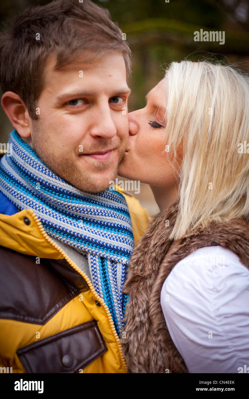 Couple kissing outside in a park Stock Photo - Alamy
