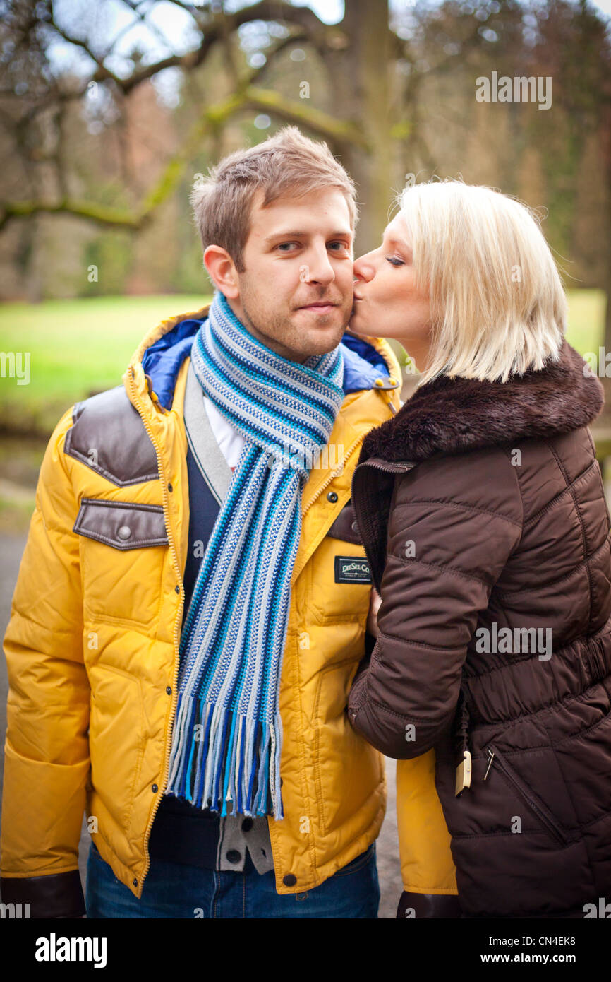 Couple kissing outside in a park Stock Photo - Alamy