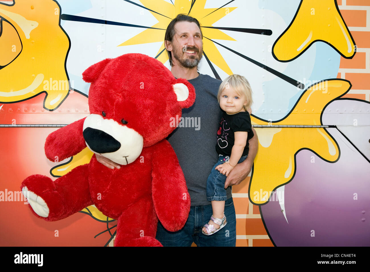 Man holding large teddy bear and son Stock Photo - Alamy