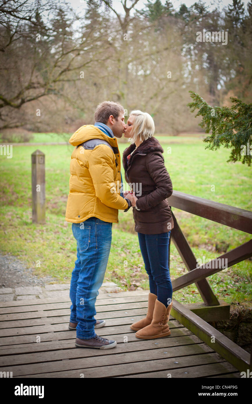 Couple kissing outside in a park Stock Photo - Alamy