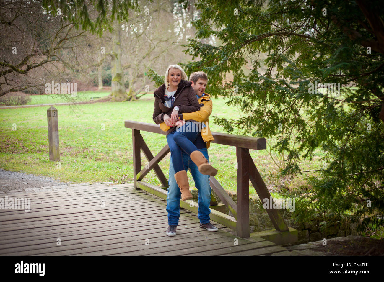 Joyful Couple Enjoying a Playful Piggyback Ride on a Park Bridge Stock ...