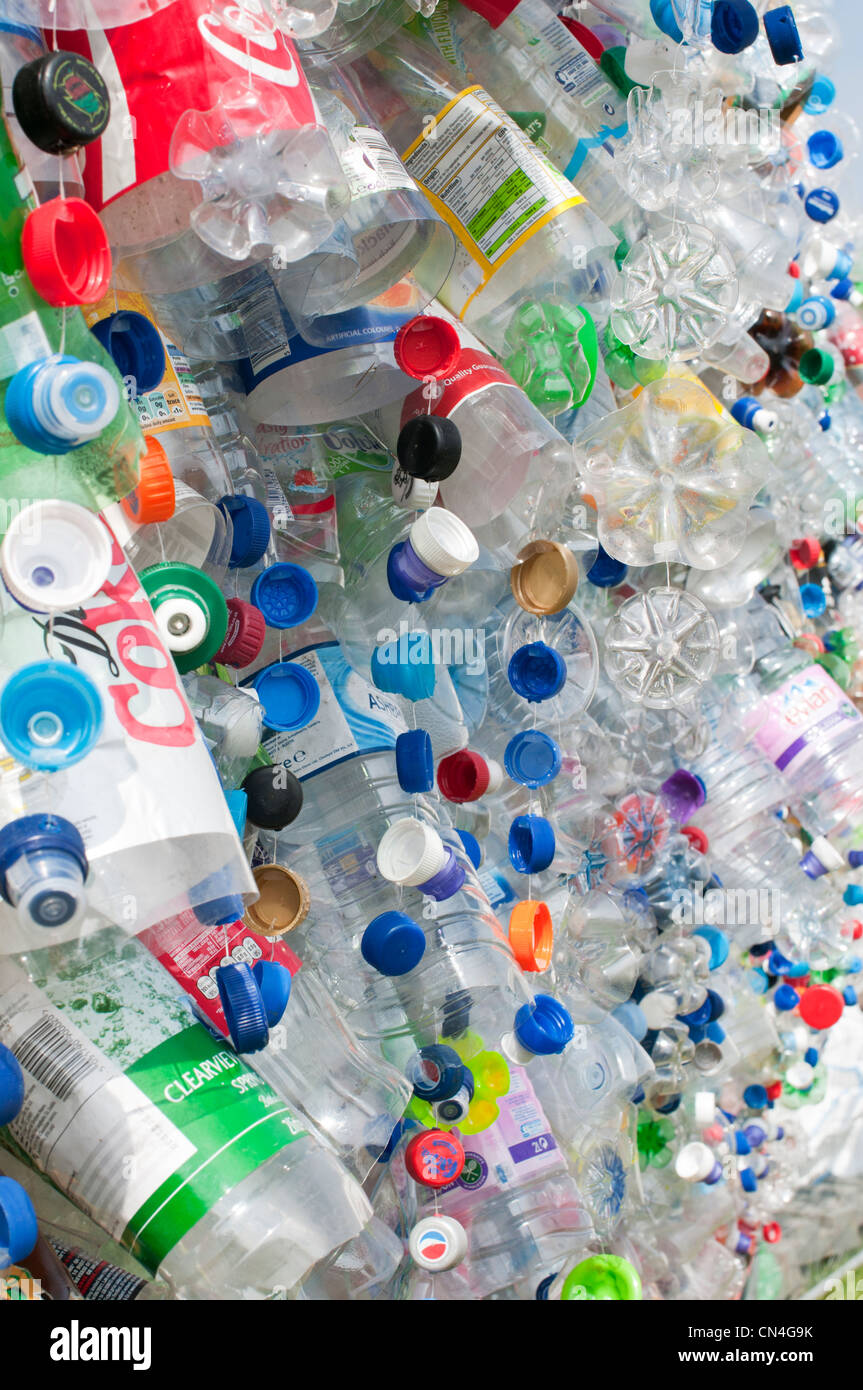 Discarded plastic bottles attached to a wire mesh fence highlight the need for more recycling of precious materials Stock Photo