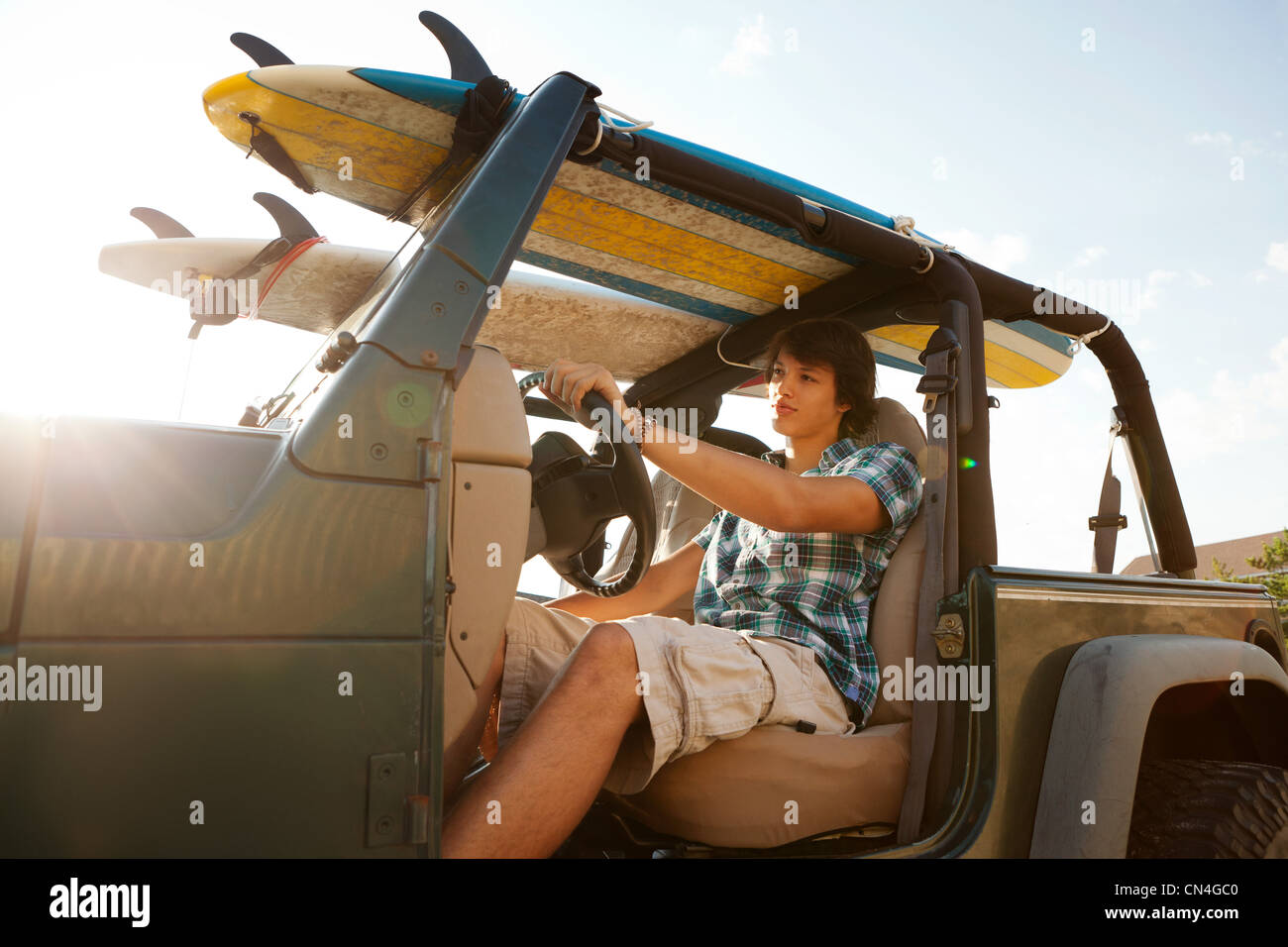 Teenager driving jeep with surfboards Stock Photo - Alamy