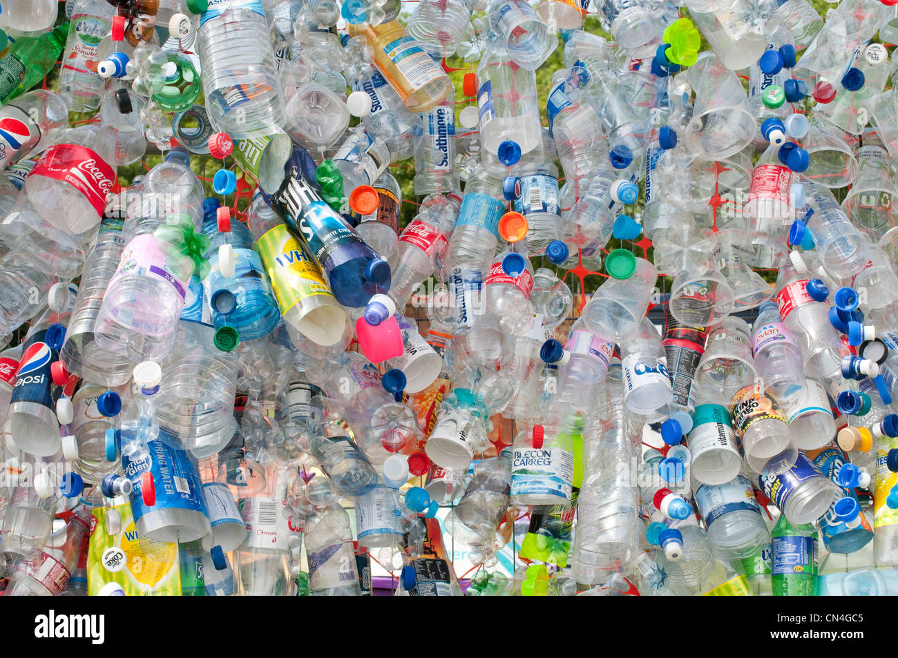 Discarded plastic bottles attached to a wire mesh fence highlight the need for more recycling of precious materials Stock Photo