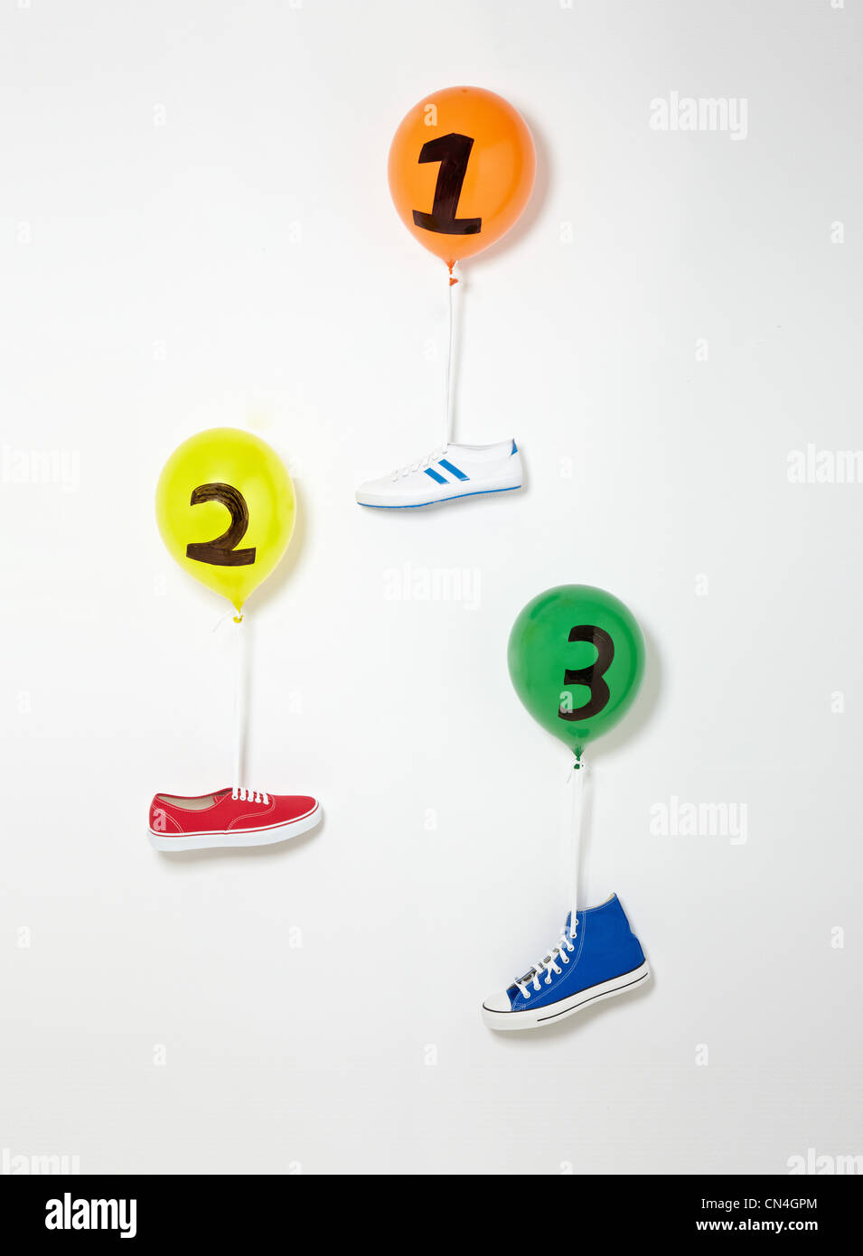 Trainers floating upward suspended by balloons Stock Photo - Alamy