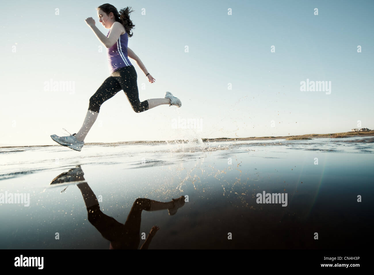 Teenage girl running on the beach with her surfboard Stock Photo Alamy