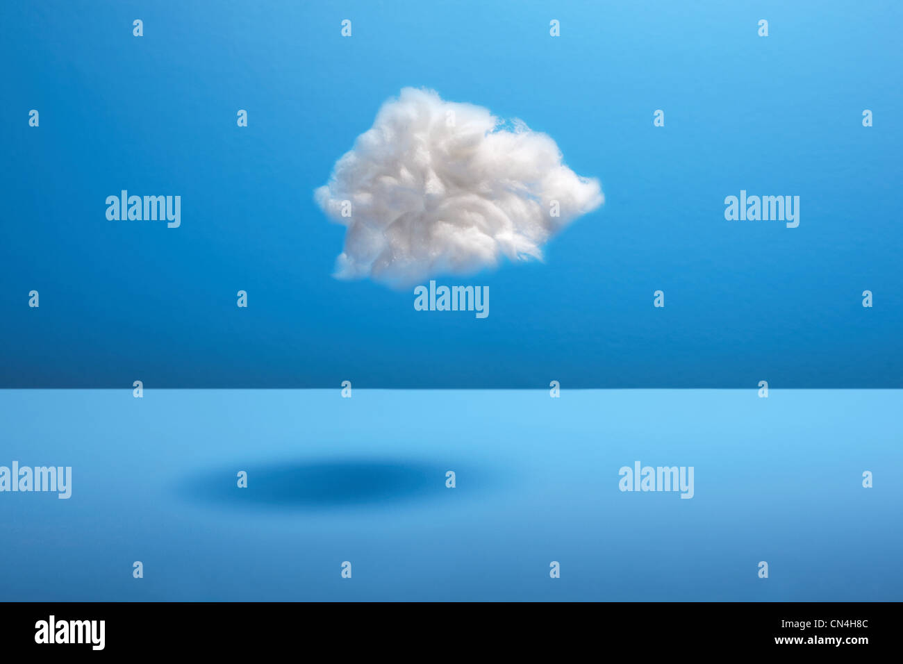 Cotton ball cloud against blue backdrop Stock Photo