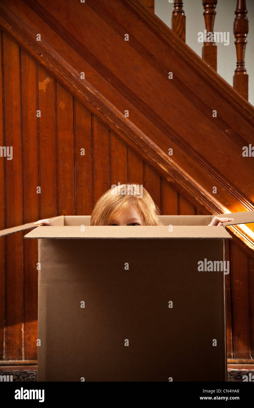 Portrait of girl hiding in cardboard box Stock Photo