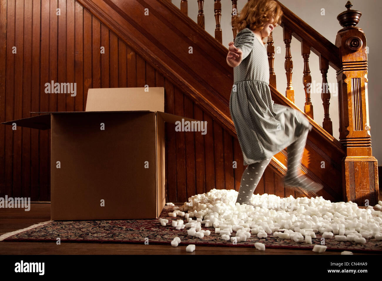 Girl playing with packing material from cardboard box Stock Photo Alamy