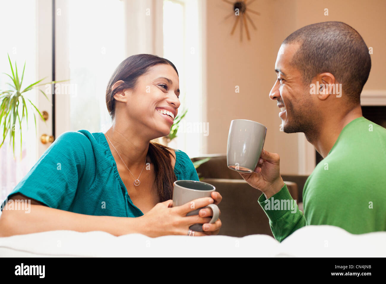 Couple relaxing with hot drink Stock Photo - Alamy