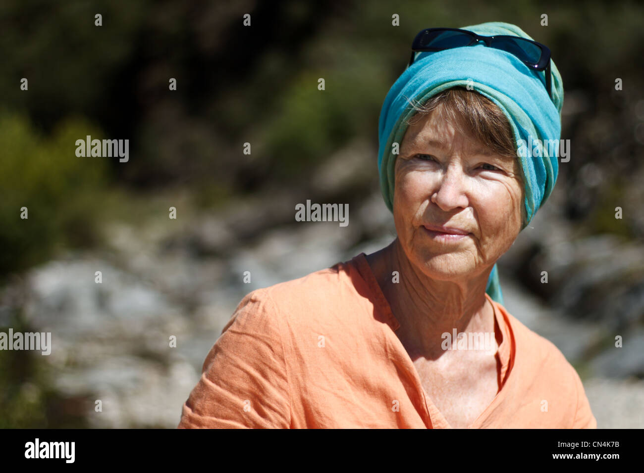 Senior woman wearing headscarf and smiling, outdoors. Stock Photo
