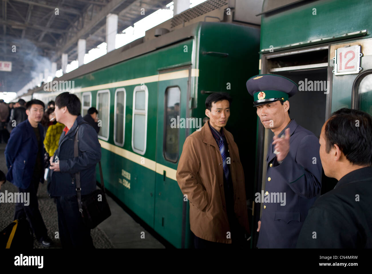 North Korea, Pyongyang, Railway station, train conductor in front the train standing by the platform Stock Photo