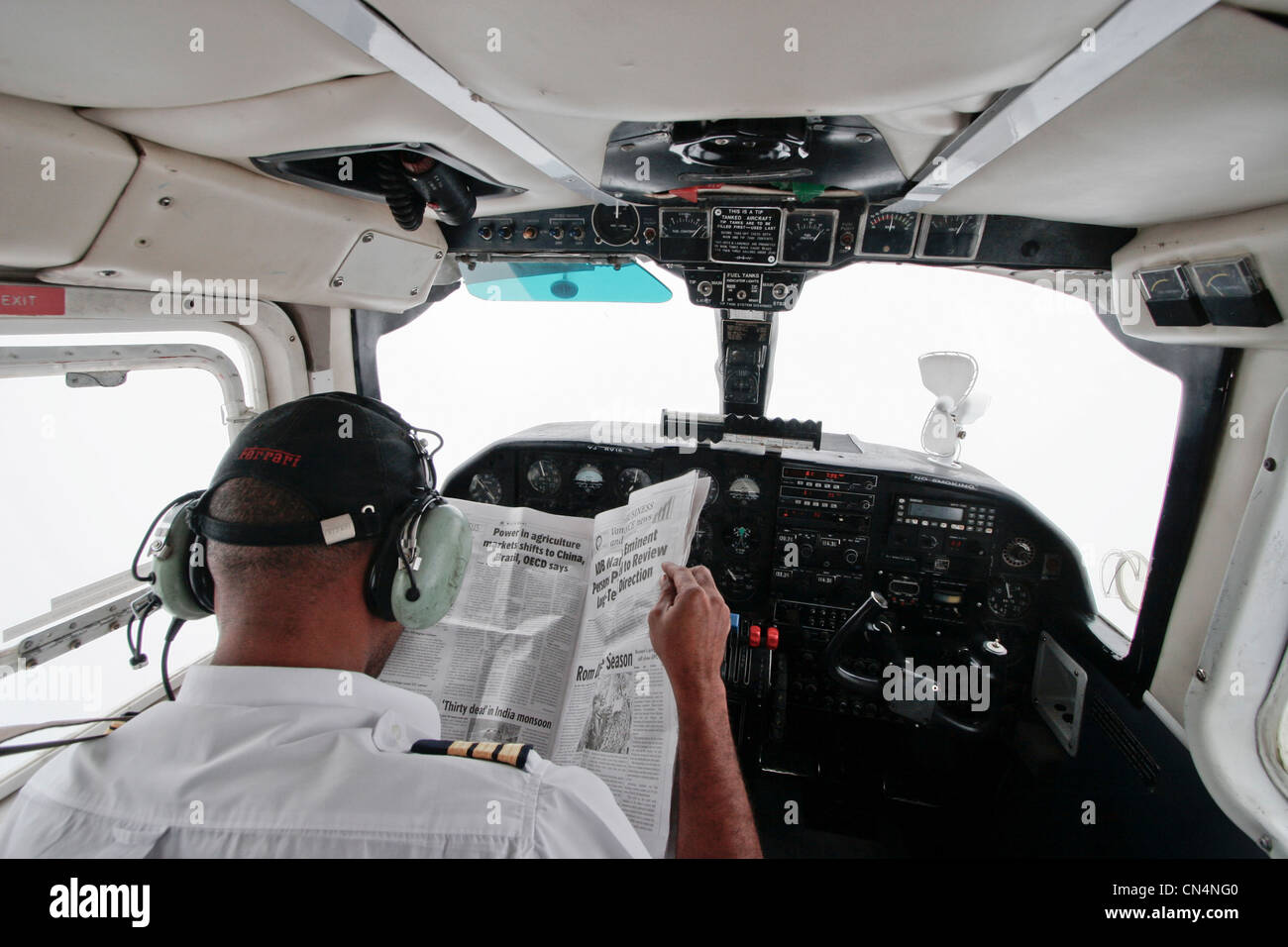 Vanuatu, Sanma Province, Espiritu Santo Island, Luganville, Air Vanuatu pilot reading the newspaper when approaching the airport Stock Photo