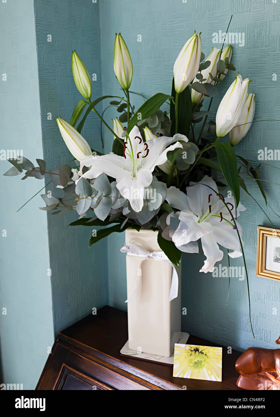 White lillies in vase as condolences following bereavement, Wales, UK Stock Photo