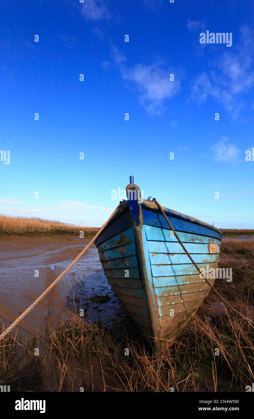 A wooden blue boat and blue sky at Brancaster Staithe on the North Norfolk coast. Stock Photo