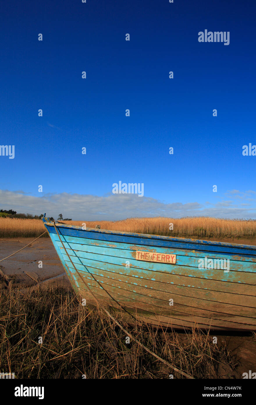 A wooden blue boat and blue sky at Brancaster Staithe on the North Norfolk coast. Stock Photo