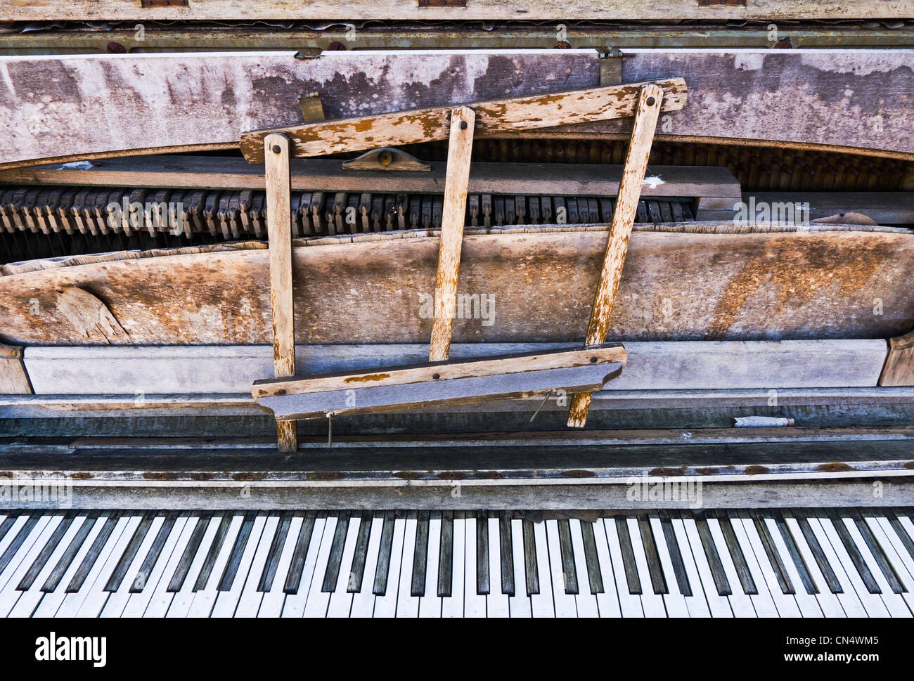 A very dilapidated, broken down upright piano. Stock Photo