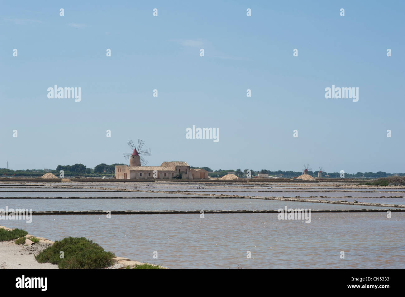View of salt pans, brine lakes and traditional windmill , Mozia, Trapani Province, Sicily, Italy Stock Photo