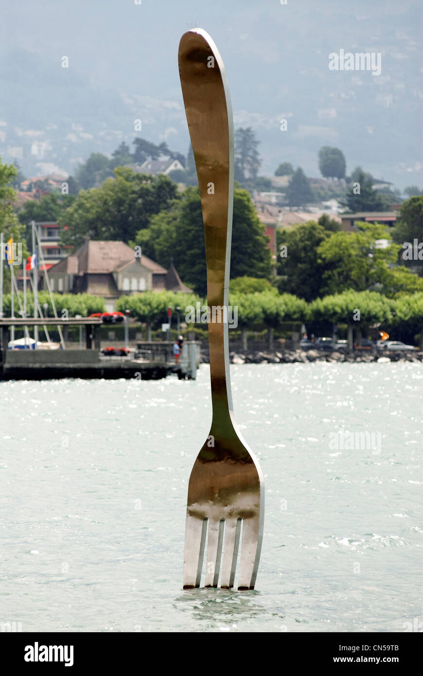 Switzerland, Canton of Vaud, Vevey, giant fork stuck in front of Lake Geneva Alimentarium sculpture by Jean Pierre Zaugg Stock Photo