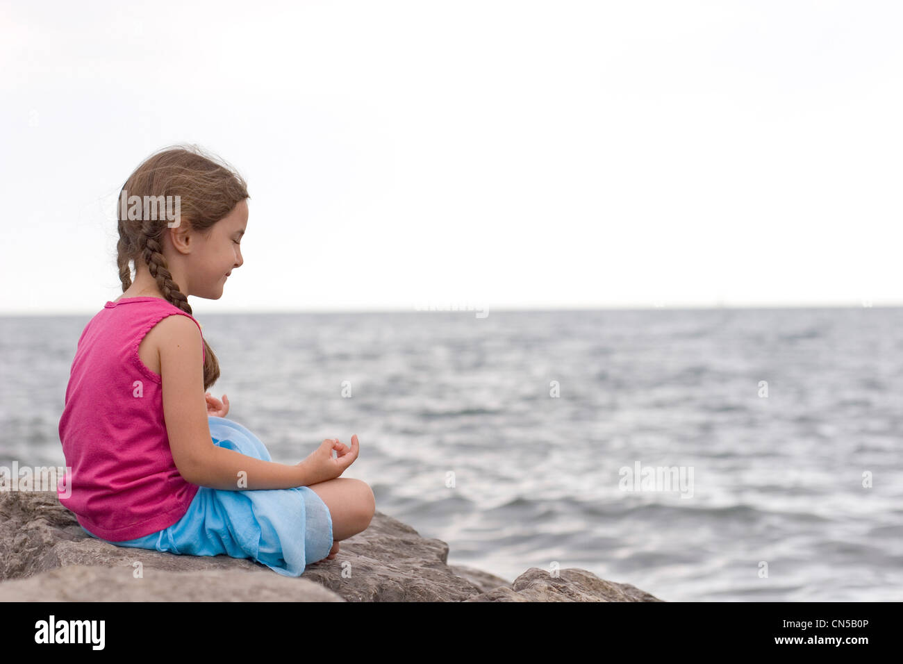 Thoughtful girl sitting on rock hi-res stock photography and images - Alamy
