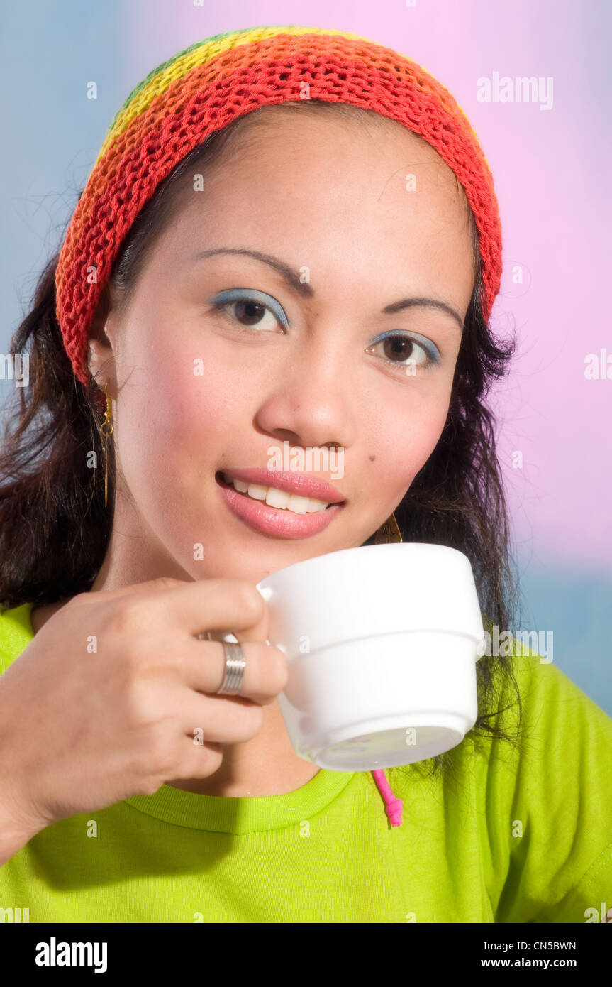 Asian model drinking tea in studio setting Stock Photo - Alamy