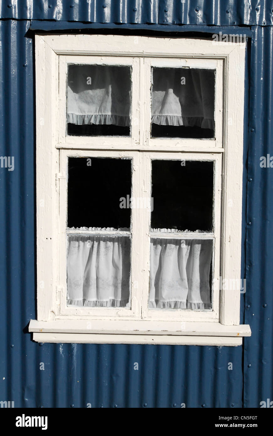 Iceland, Austurland Region, Faskrudsfjordur, wooden window painted in white and wall of sheet steel paints in blue Stock Photo