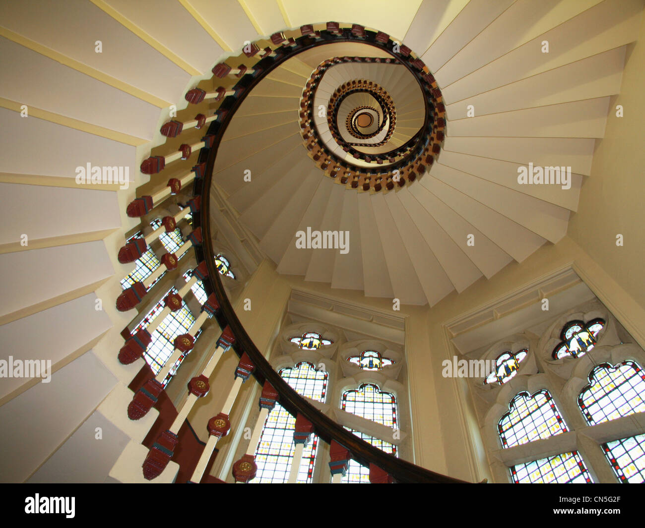 Spiral staircase at Rochdale Town Hall, Lancashire, flanked by stained glass windows looking from below. Stock Photo