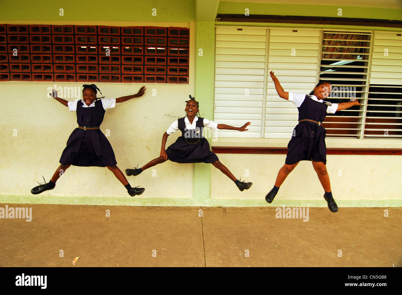 Barbados Island, Farmers, portrait of schoolgirls jumping with their legs  spread apart, wearing school uniform outside school Stock Photo - Alamy