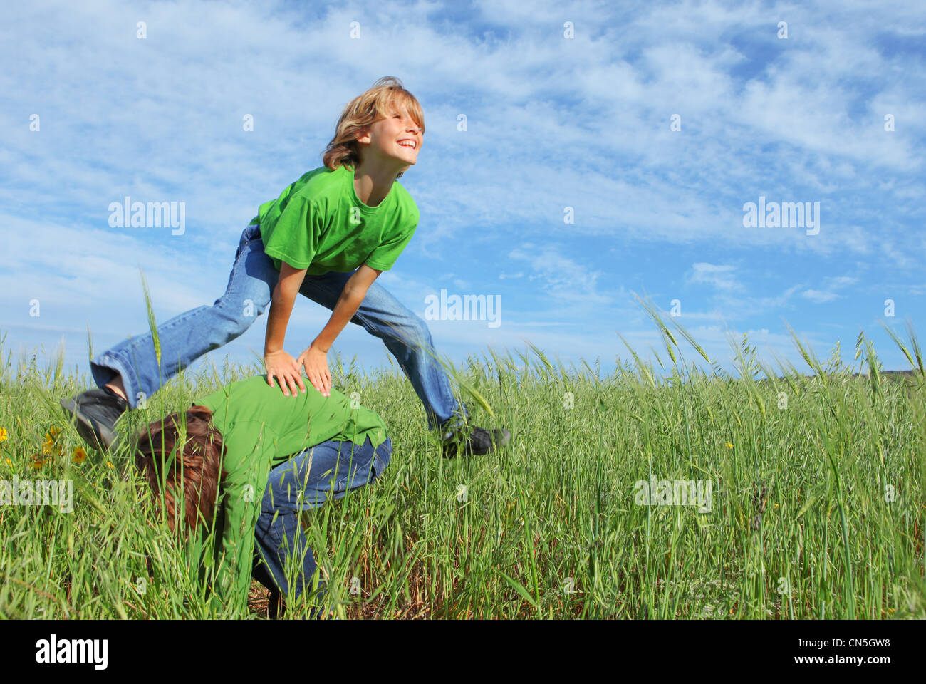 happy healthy kids playing leapfrog Stock Photo