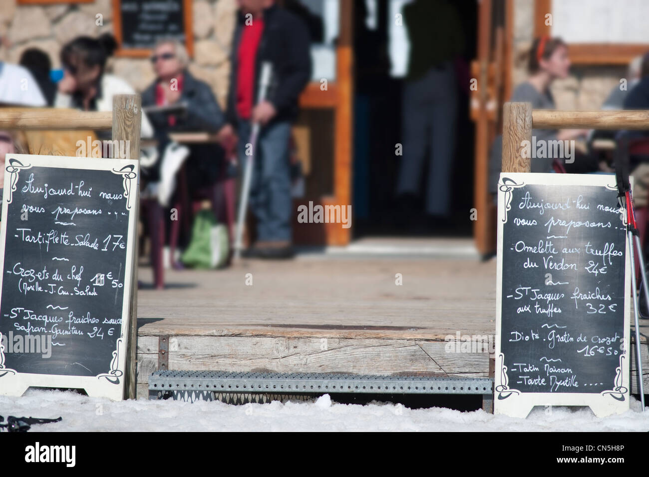 Mountain chalet restaurant with menu board and skiers at La Plagne in the French Savoie Alps Stock Photo