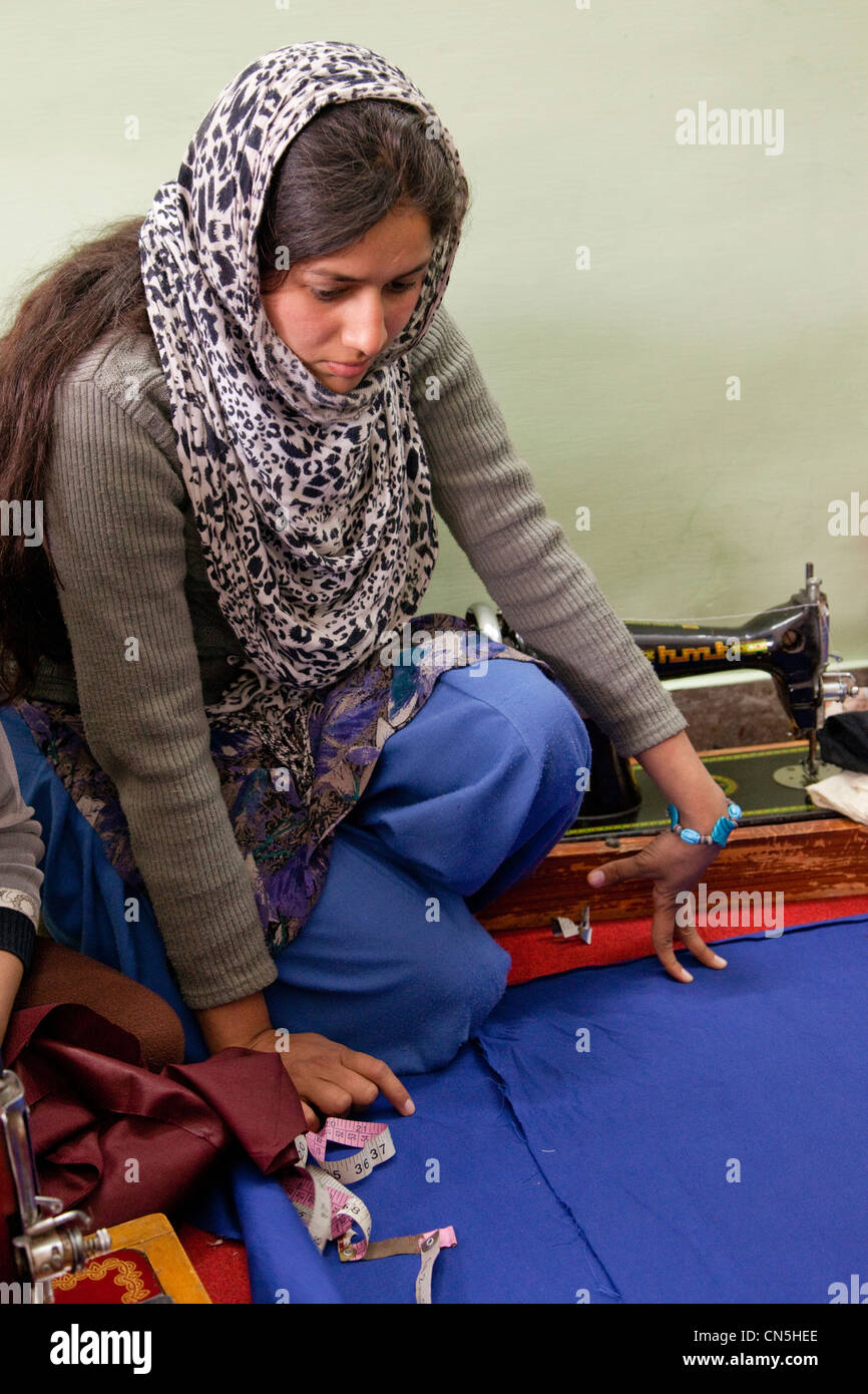 Dehradun, India. Indian Muslim woman studying cloth before measuring and cutting. Stock Photo